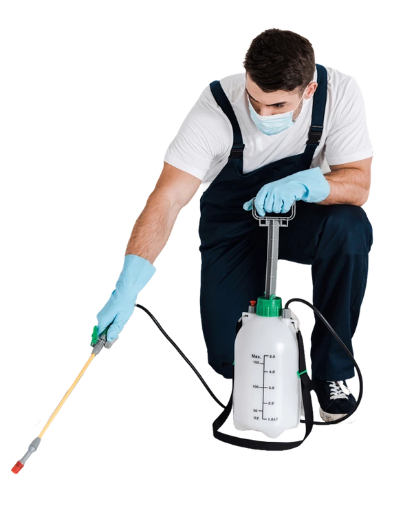 A specialist in a white protective suit and respirator mask operating a motorized handheld spray machine